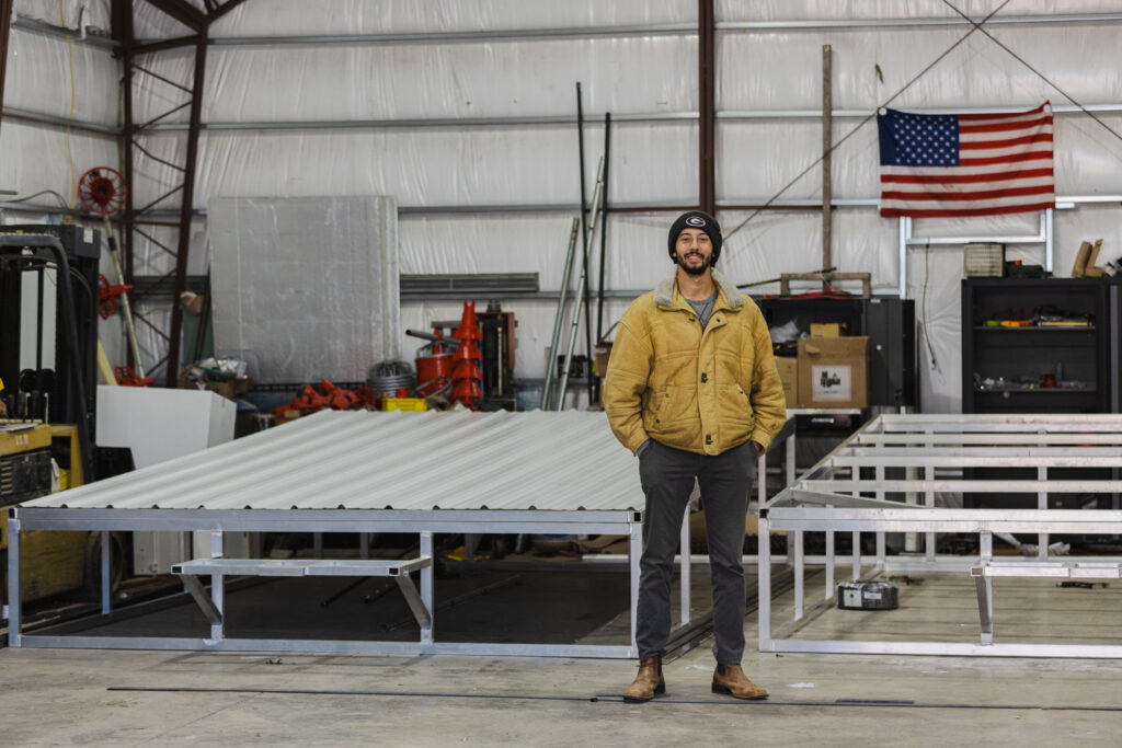 Man stands in front of automated chicken coops