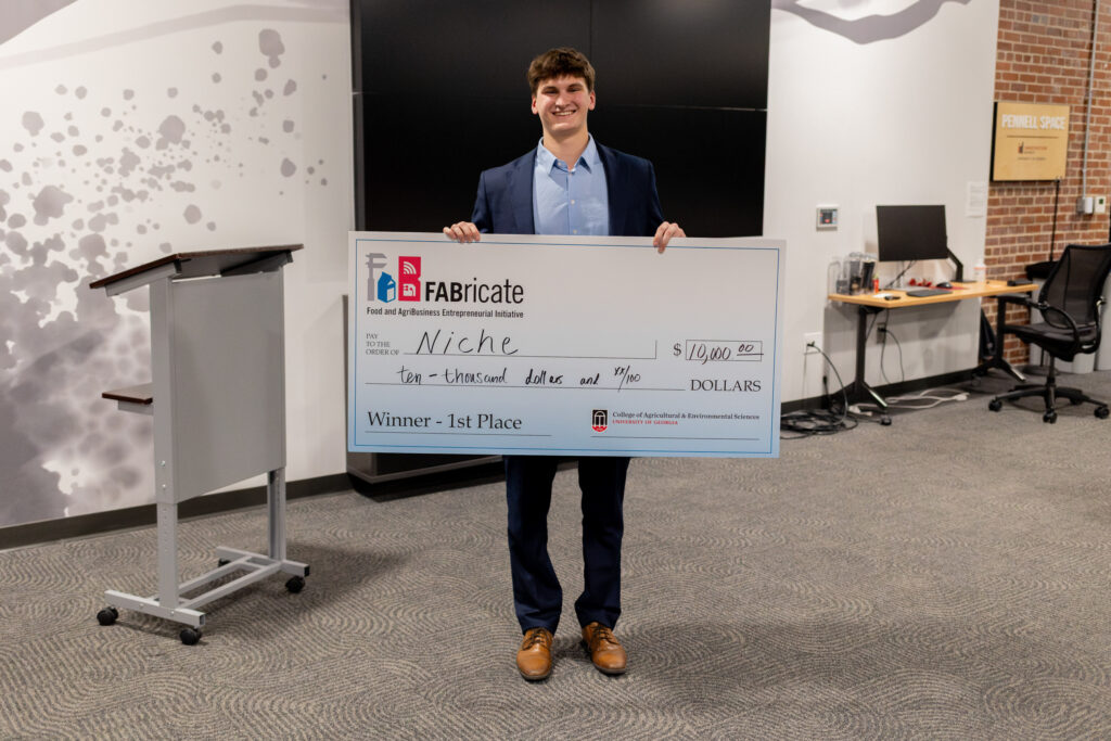 Man holds winning check from FABricate contest